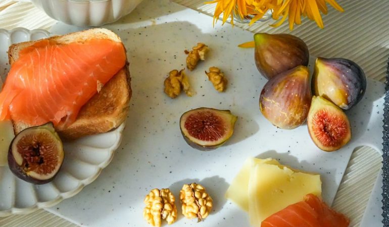 Cozy breakfast with tea, figs, cheese and salmon toasts