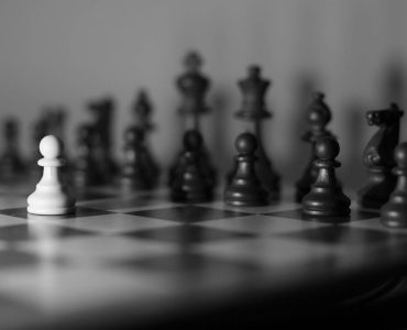 Chessboard with a white pawn against all the others