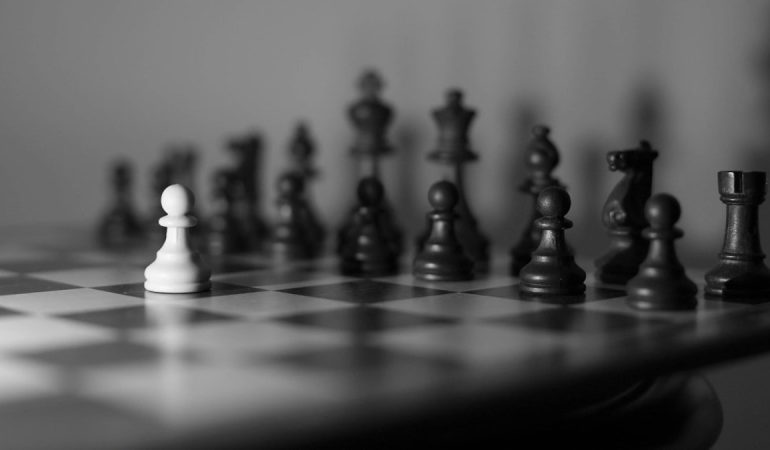 Chessboard with a white pawn against all the others